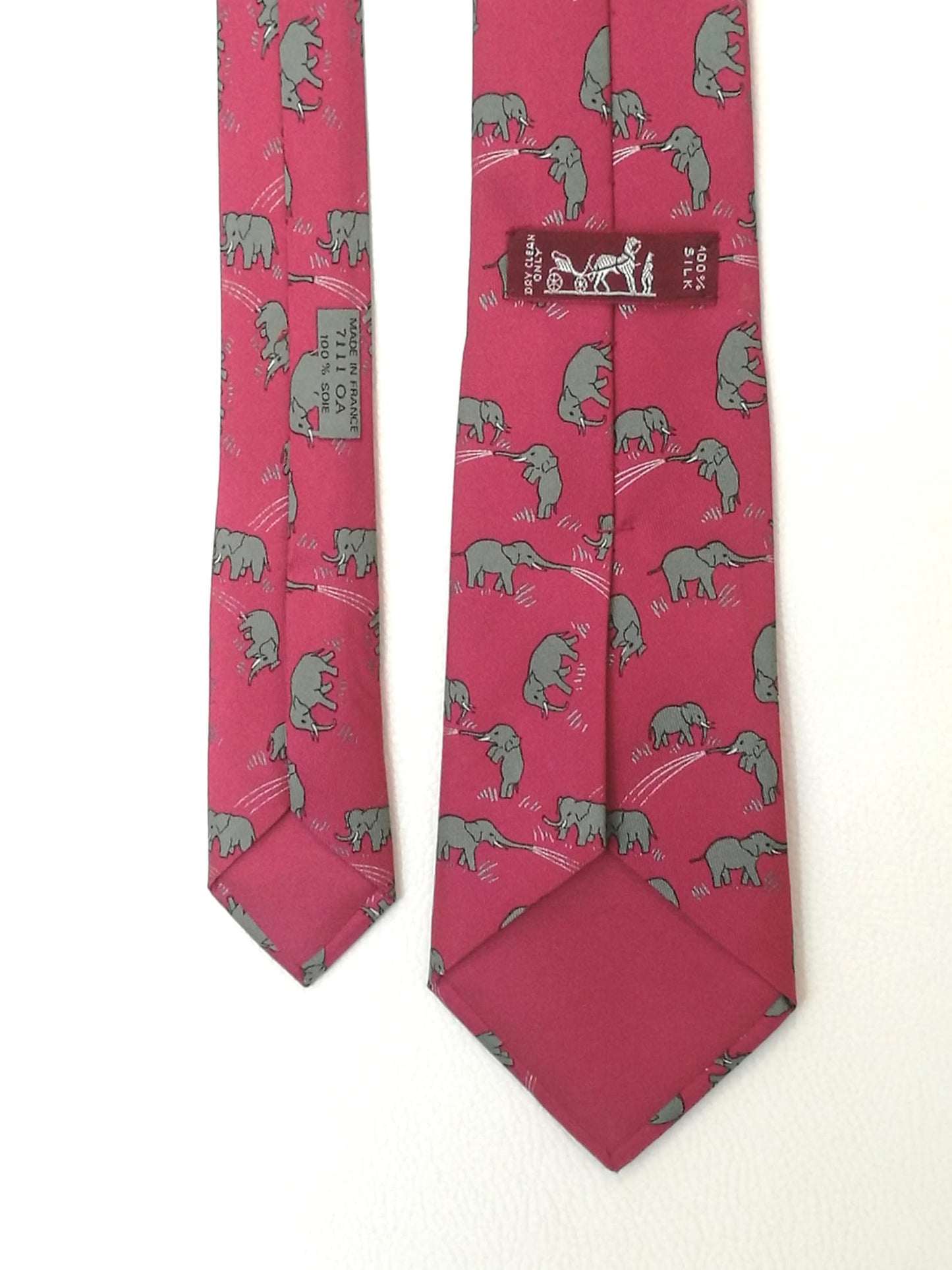 Cravatta Hermès con sfondo rosa con elefanti grigi.