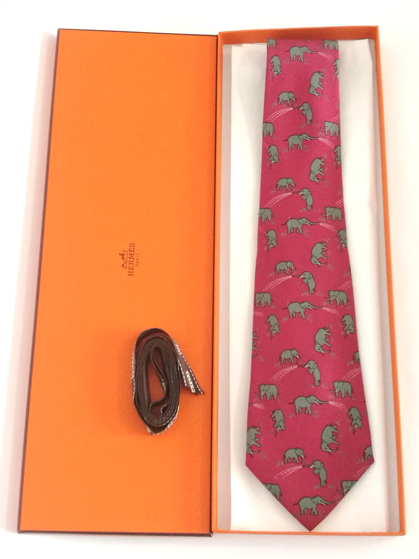 Cravatta Hermès con sfondo rosa con elefanti grigi.